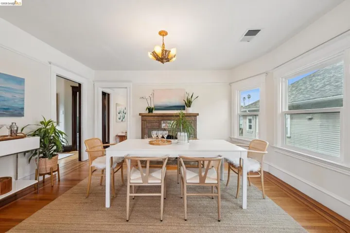 Dining room features the stunning original lighting fixtures, oak hardwood floors with walnut inlay and a gorgeous fireplace.