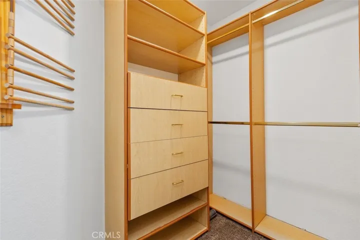 Walk in closet in the primary bedroom with built ins.