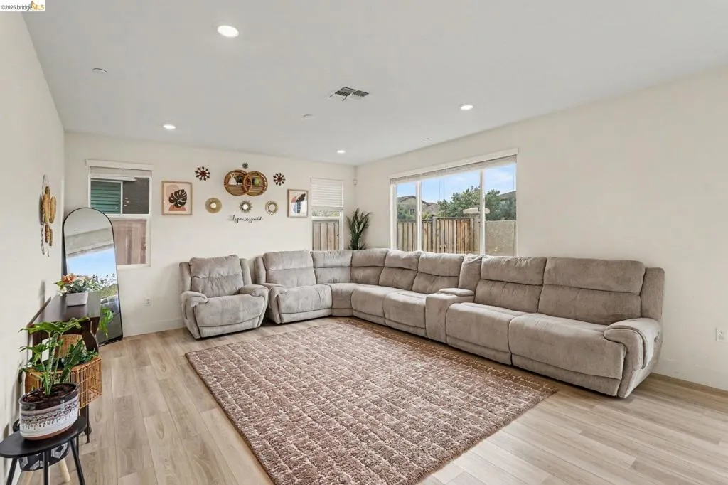 Spacious interior featuring wood-finish flooring, recessed lighting, and ample natural light from multiple windows