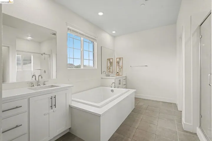 Contemporary bathroom featuring a built-in soaking tub, a dual vanity with undermount sinks, and a separate glass-enclosed shower