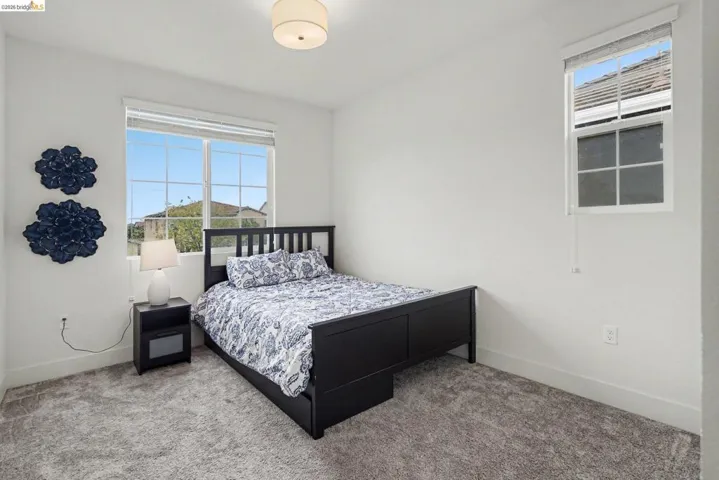 Bright interior space with light gray wall-to-wall carpeting and crisp white walls