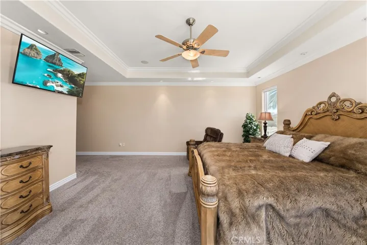 Primary Bedroom with Coffered Ceiling, Recessed Lighting, Ceiling Fan and Sliding Door to the Backyard,