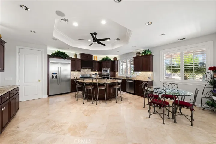 View of the Kitchen from the Family Room- Recessed Lighting, Coffered Ceiling, Ceiling Fan and Large Walk In Pantry