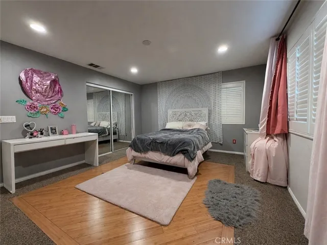 Upstairs bedroom with hardwood section in the middle