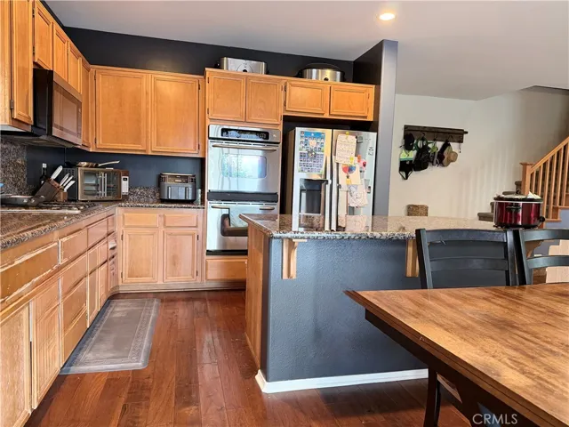 Kitchen with long cupboards/food prep ara, island with breakfast bar, and room for a separate eating table