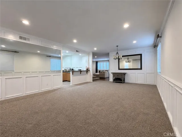 Front dining room and living room combo. Wet bar to the left side. Doorway to kitchen/family room area through the middle back.