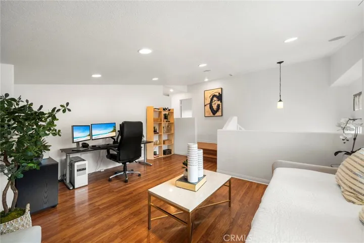 Loft has Recessed Lighting and Wood Laminate Flooring