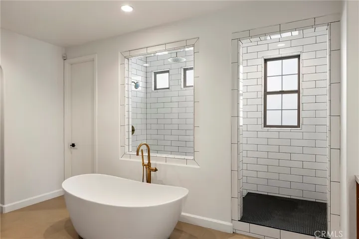 Remodeled primary bathroom with soaking tub, oversized walk-in shower