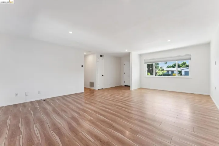 Empty room featuring light wood-type flooring and recessed lighting