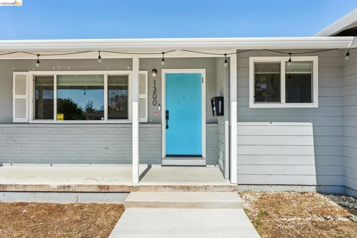 Doorway to property with a porch and brick siding