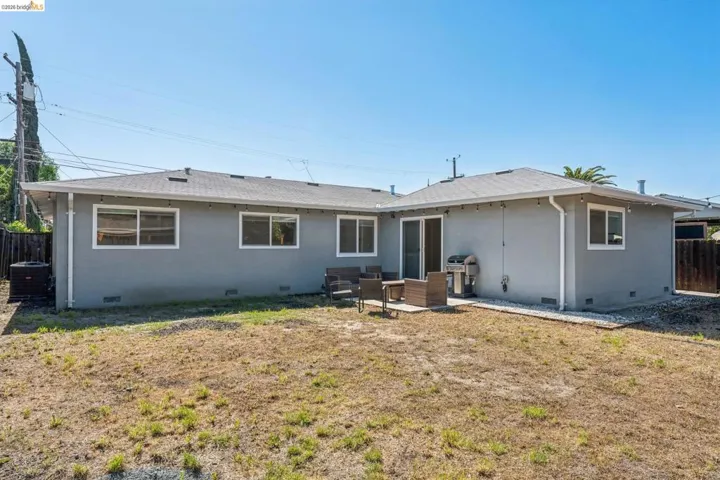 Back of property featuring crawl space, a shingled roof, and a patio area