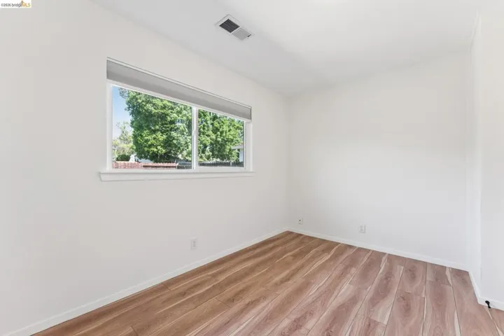 Empty room featuring light wood finished floors and baseboards