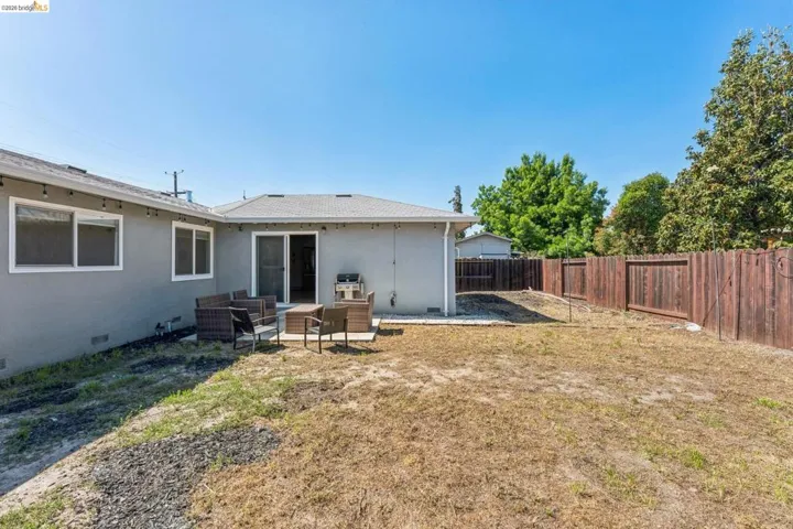 Back of property with crawl space, outdoor furniture, a patio area, a fenced backyard, and stucco siding