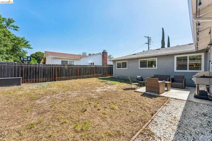 Fenced backyard with outdoor seating and a patio