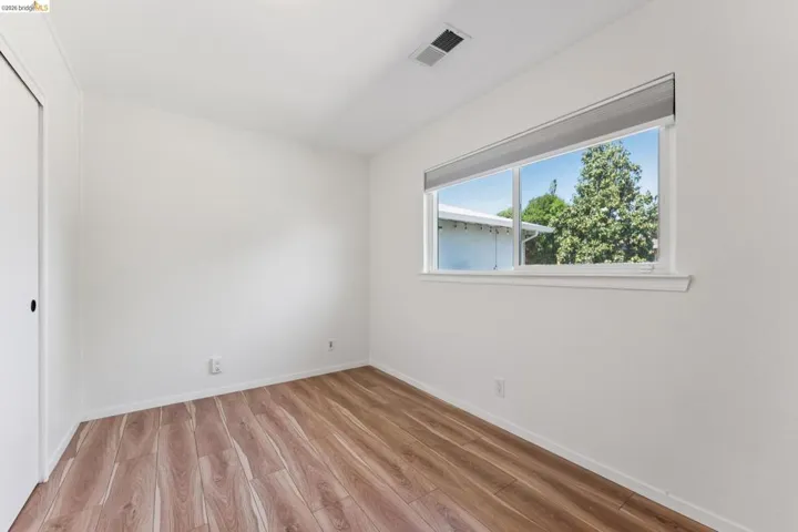 Unfurnished bedroom with light wood finished floors and a closet