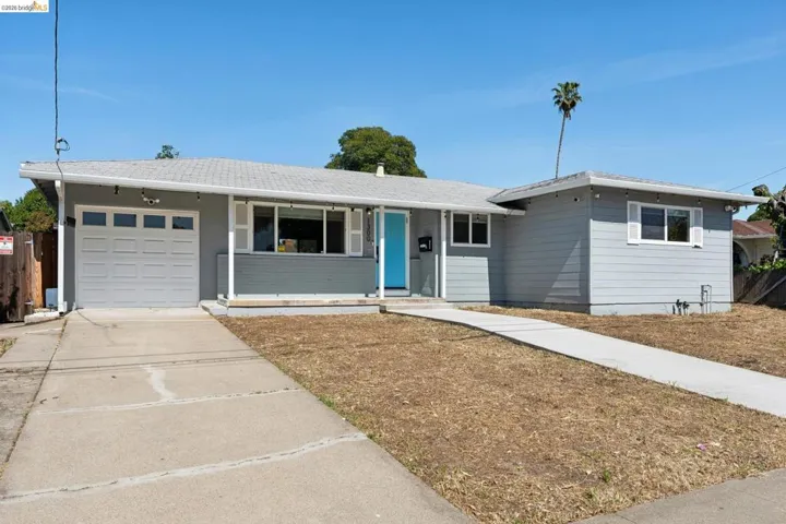 Single story home with concrete driveway, a garage, and a porch