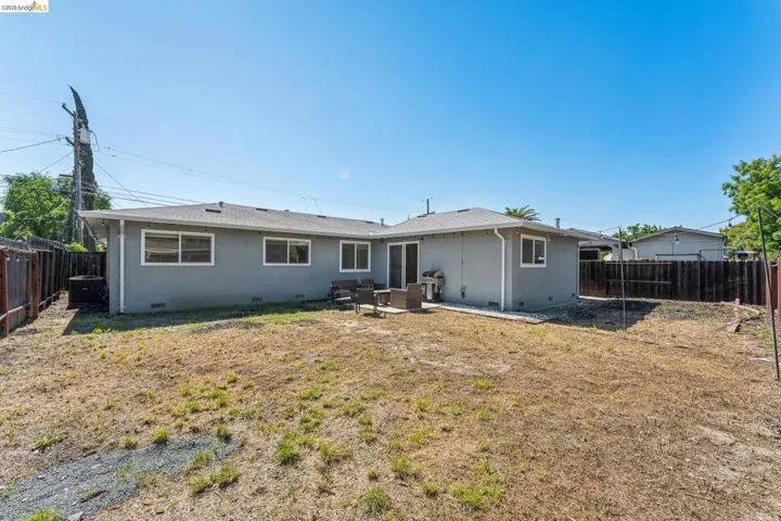 Back of property with a patio, a fenced backyard, and crawl space