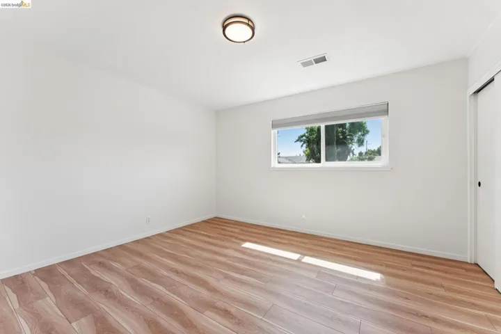 Unfurnished bedroom with light wood-style flooring and a closet