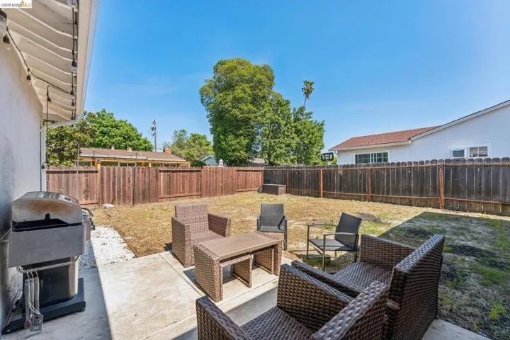 Fenced backyard featuring a patio and grilling area