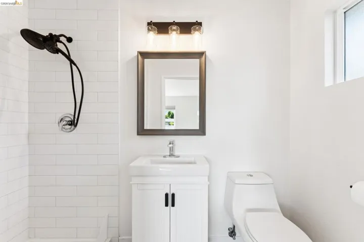 Full bathroom featuring tiled shower and vanity