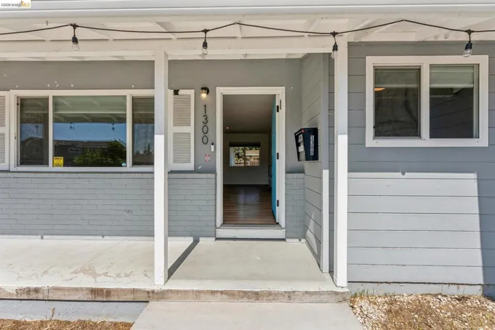 View of exterior entry featuring a porch and brick siding
