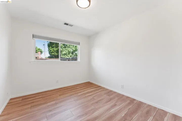 Empty room with light wood-style floors and baseboards