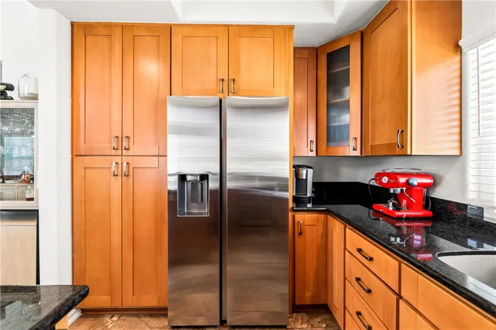 Pantry with pull out shelving and stainless refrigerator.