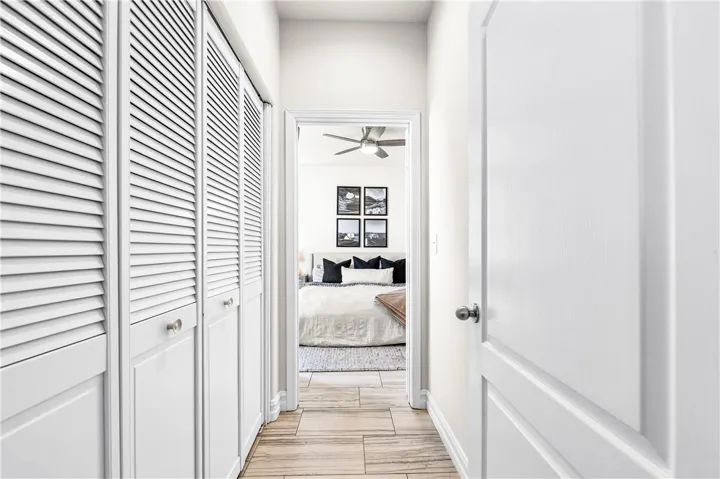 Hallway from foyer to the primary bedroom, shuttered doors on the left house the indoor laundry.