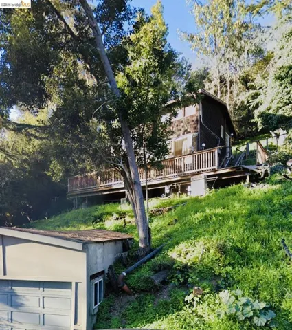 Two-story residence with dark wood siding and a multi-level wood deck