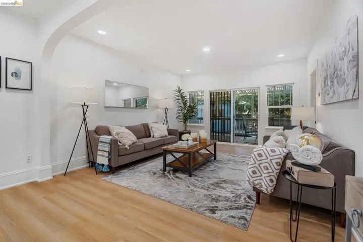 Living space featuring light wood-finish flooring, recessed lighting, and an arched entryway