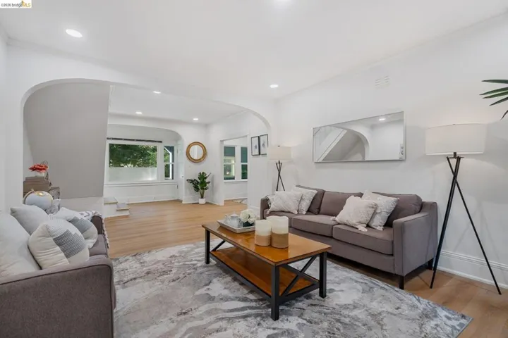 Open-concept living space featuring wood-finish flooring, recessed lighting, and arched doorways