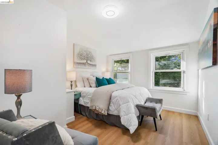 Spacious room featuring light wood-finish flooring and bright white walls