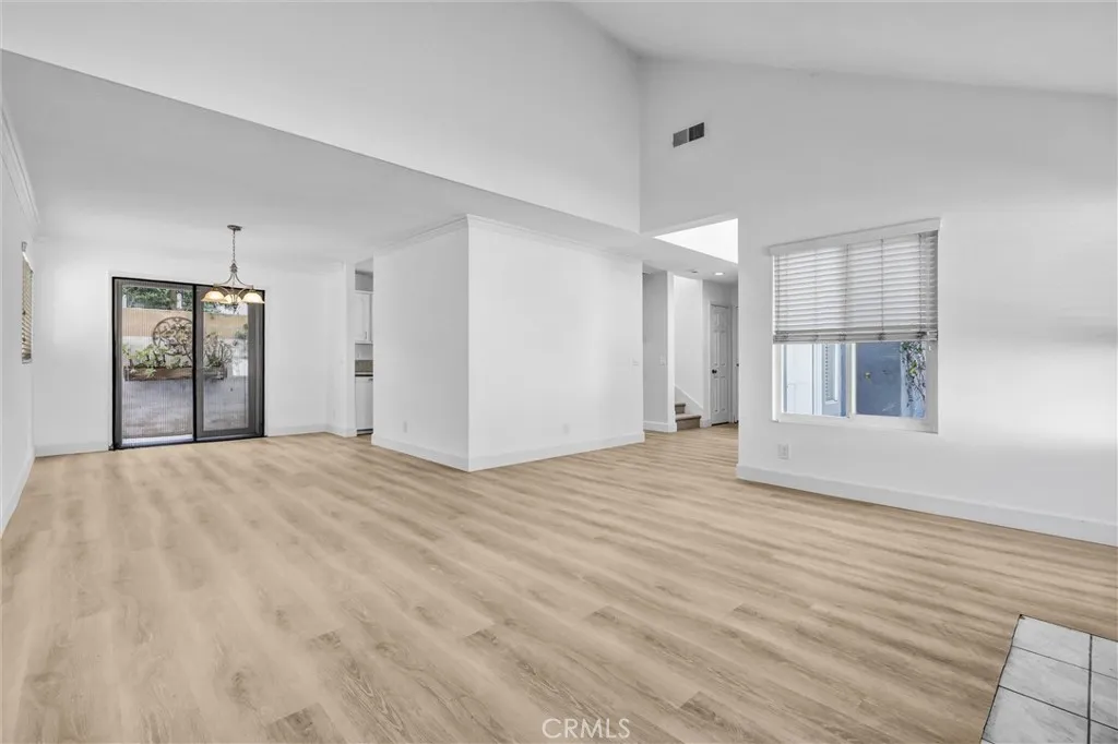 Full View of good sized Dining Area with chandelier light above the table area - Kitchen to the right
