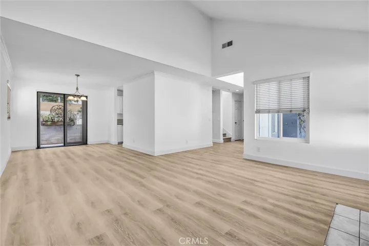 Full View of good sized Dining Area with chandelier light above the table area - Kitchen to the right