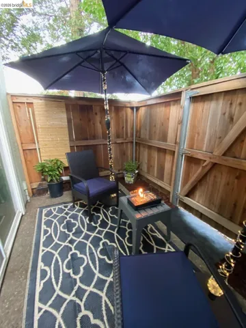 Private patio space featuring wood fencing and an outdoor area rug