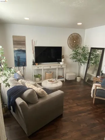 Living area featuring dark wood-finish flooring and recessed ceiling lighting