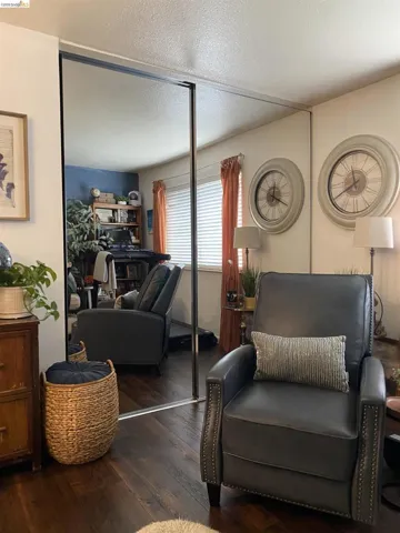 Floor-to-ceiling mirrored closet doors enhance the space, complementing the rich wood-finish flooring