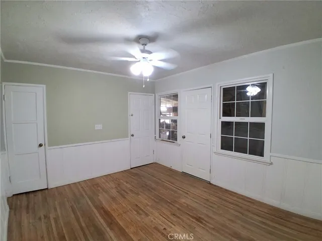Bright and inviting primary bedroom with hardwood flooring and a comfortable, open feel.