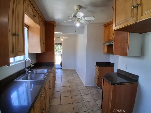 The kitchen features ample wood cabinets, tile flooring, and plenty of workspace for everyday cooking.