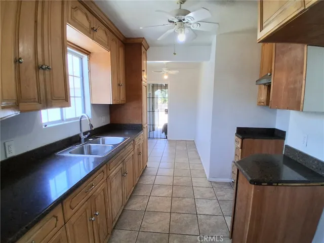 Spacious kitchen with warm wood cabinetry and attractive tile flooring.