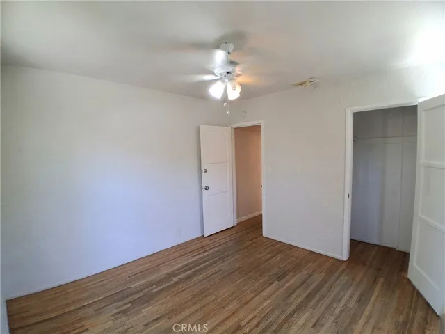 Inviting first bedroom featuring a bright, airy atmosphere and ceiling fan.