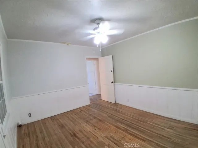The primary bedroom offers a bright, spacious atmosphere with stylish hardwood flooring.