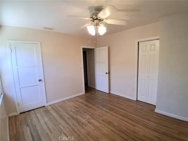 Inviting second bedroom with a bright layout, ceiling fan, and comfortable living space.