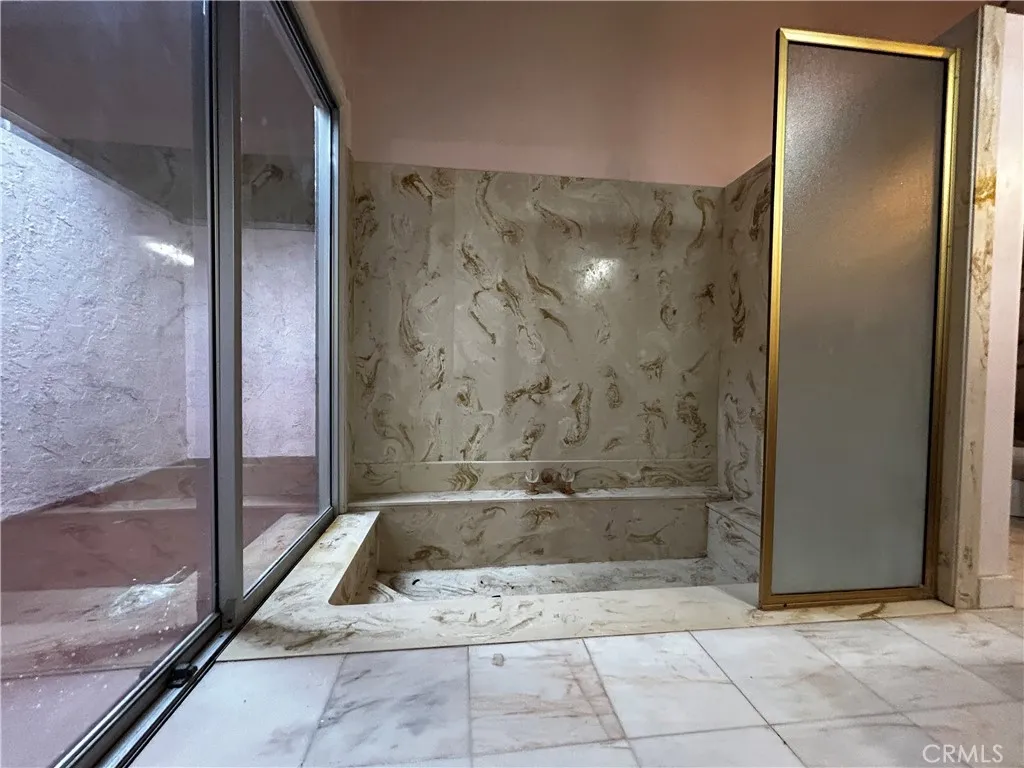 Full bath with sunken bathtub & extra room with skylight