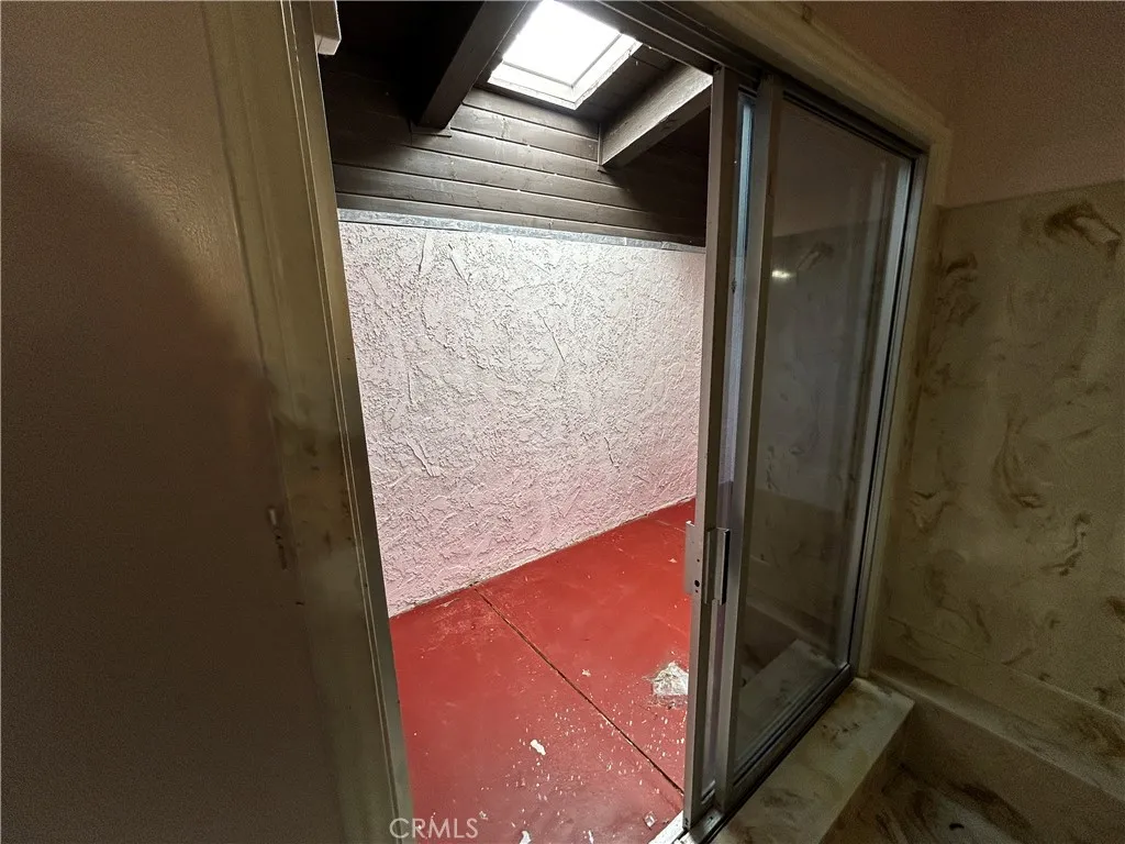 Full bath with sunken bathtub & extra room with skylight
