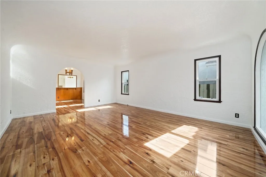 Living room with Arched doorway to formal Dining room and stunning wood laminate floors throughout.