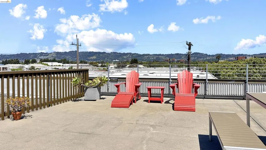 Expansive rooftop deck with a sturdy wood-finish railing and a metal wire barrier