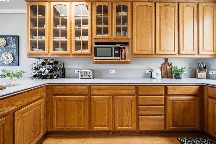 Spacious kitchen featuring extensive wood cabinetry, light-toned countertops, and a built-in microwave