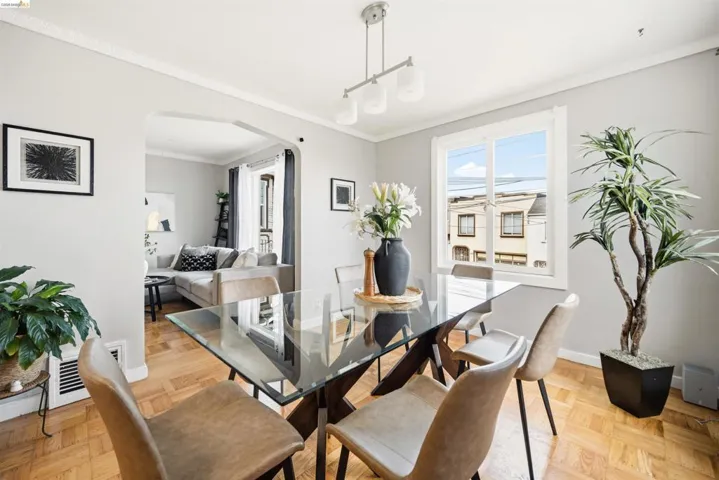 Dining area featuring wood-finish parquet flooring, a modern chandelier, and an arched doorway