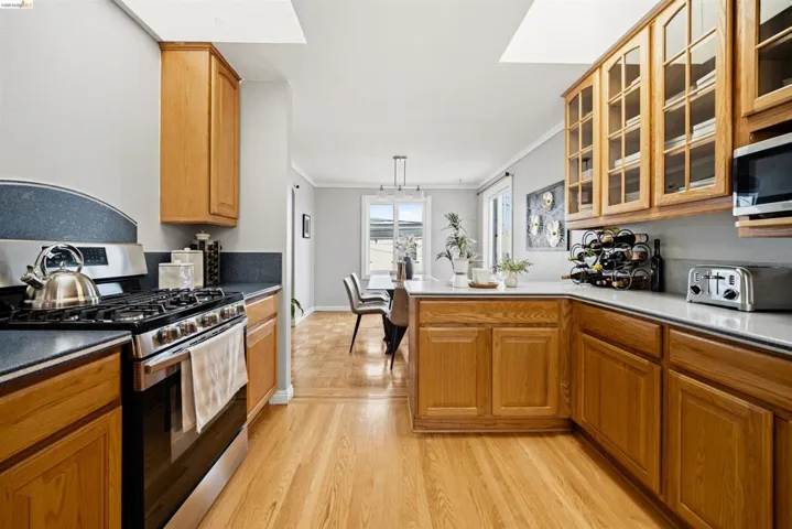 Kitchen featuring wood-finish cabinetry, stainless steel range, and light countertops
